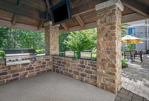 an outdoor patio with a brick wall and a grill at Homewood Suites by Hilton Eatontown in Eatontown