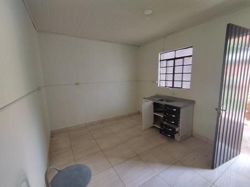 an empty room with a desk and a window at Kitnet in Ponta Porã