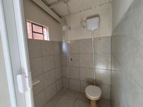 a bathroom with a shower with a toilet and a window at Kitnet in Ponta Porã