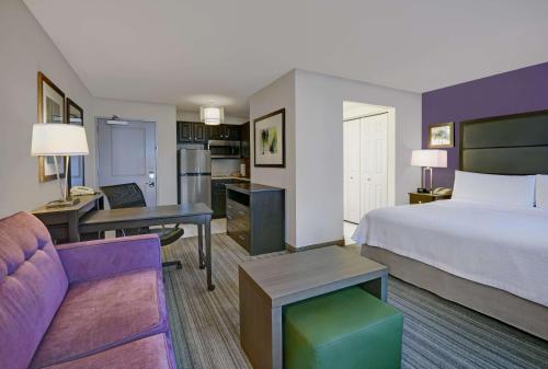 a hotel room with a bed and a living room at Homewood Suites by Hilton Eatontown in Eatontown