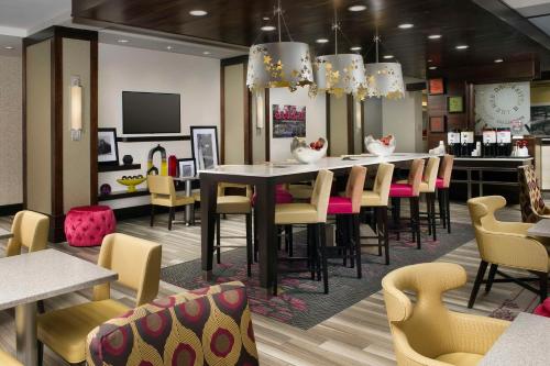 a restaurant with a bar with tables and chairs at Hampton Inn by Hilton Hattiesburg in Hattiesburg