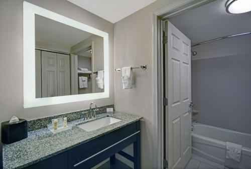 a bathroom with a sink and a mirror and a shower at Homewood Suites by Hilton Eatontown in Eatontown