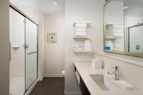 Baño blanco con lavabo y espejo en Hampton Inn by Hilton Hattiesburg, en Hattiesburg