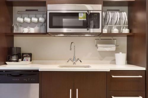 a kitchen with a sink and a microwave at Home2 Suites by Hilton Greenville Downtown in Greenville