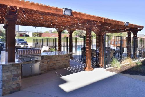 a wooden pergola with a grill on a patio at Homewood Suites by Hilton Trophy Club Southlake in Trophy Club
