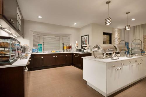 una grande cucina con banconi bianchi e piano di lavoro di Homewood Suites Jacksonville Deerwood Park a Jacksonville
