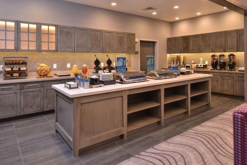 a large kitchen with wooden cabinets and a large island at Homewood Suites by Hilton Trophy Club Southlake in Trophy Club