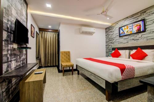 a hotel room with a bed and a tv at Pratibha Grand in Vijayawāda