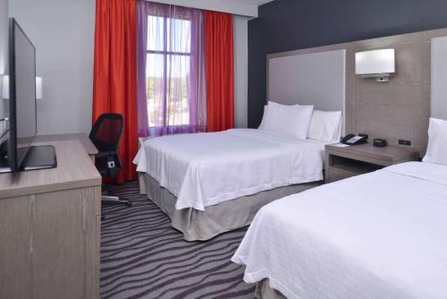 a hotel room with two beds and a television at Homewood Suites by Hilton Trophy Club Fort Worth North in Trophy Club