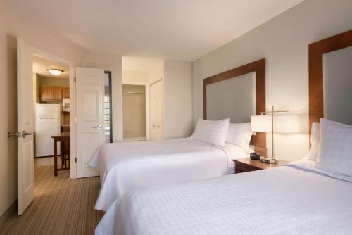 Habitación de hotel con 2 camas y cocina en Homewood Suites Jacksonville Deerwood Park, en Jacksonville