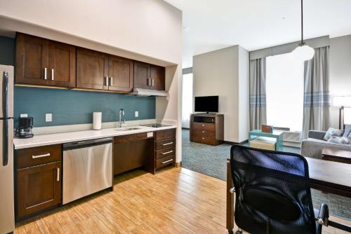 a kitchen with a sink and a chair in a room at Homewood Suites By Hilton Galveston in Galveston