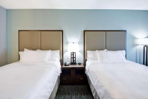 two beds sitting next to each other in a hotel room at Homewood Suites By Hilton Galveston in Galveston