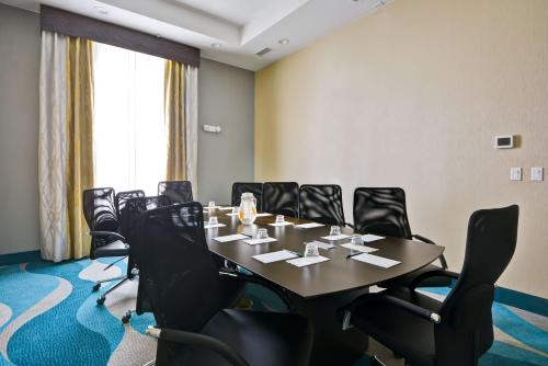 a conference room with a table and black chairs at Homewood Suites By Hilton Galveston in Galveston