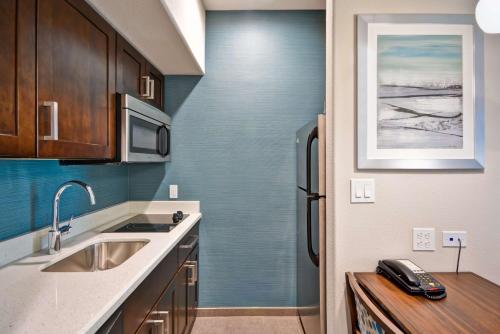 a kitchen with a sink and a refrigerator at Homewood Suites By Hilton Galveston in Galveston