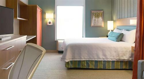 a hotel room with a bed and a television at Home2 Suites by Hilton Downingtown Exton Route 30 in Downingtown
