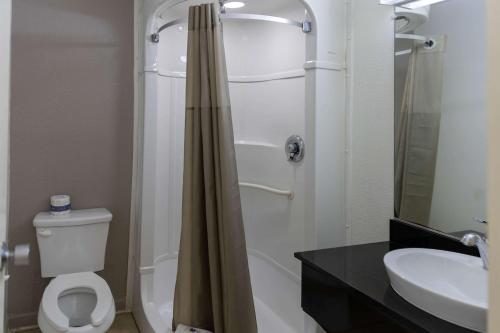 uma casa de banho com um chuveiro, um WC e um lavatório. em Motel 6-Lufkin, TX em Lufkin