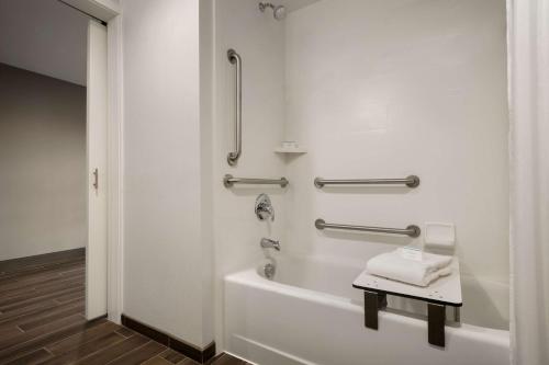 een witte badkamer met een bad en een tafel bij Hampton Inn Kernersville in Kernersville