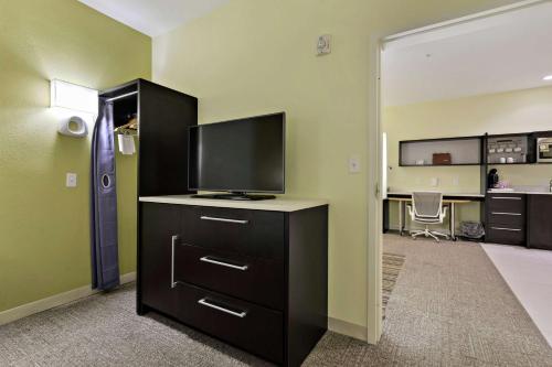 a living room with a television on a dresser at Home2 Suites by Hilton Gulfport I-10 in Gulfport
