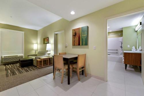 a dining room with a table and a living room at Home2 Suites by Hilton Gulfport I-10 in Gulfport