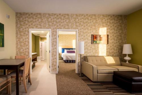 uma sala de estar com um sofá e um quarto em Home2 Suites by Hilton Gulfport I-10 em Gulfport