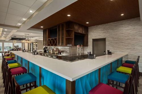 a bar with colorful bar stools in a restaurant at Hilton Garden Inn Houston-Baytown in Baytown