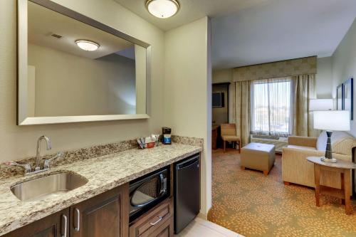 a kitchen with a sink and a living room at Hampton Inn & Suites - Hartsville, SC in Hartsville
