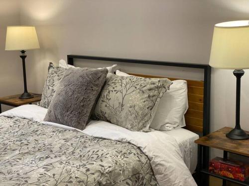 a bedroom with a bed with pillows and two lamps at Lake Orignal Waterfront SPA Pool Tremblant SKI in Val-des-Lacs