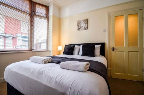 a bedroom with a large bed with two towels on it at Fitzwilliam House -3 Bed House in Redcar