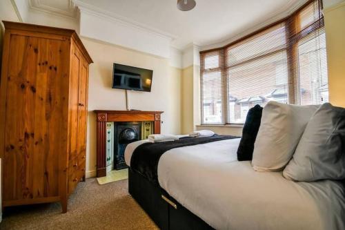 a bedroom with a bed and a tv on the wall at Fitzwilliam House -3 Bed House in Redcar