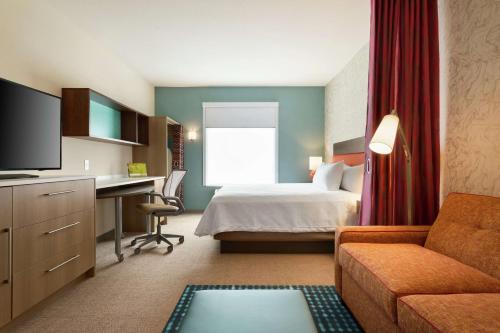 a hotel room with a bed and a desk at Home2 Suites By Hilton Frederick in Frederick