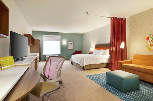 Home2 Suites By Hilton Frederick في فريدريك: غرفة في الفندق مع سرير ومكتب