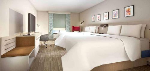 a hotel room with two large beds and a television at Hilton Garden Inn Houston Hobby Airport in Houston