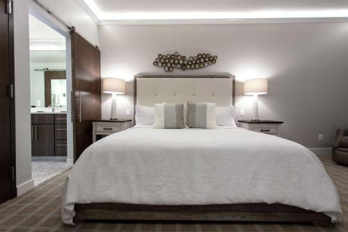 a bedroom with a large white bed with two lamps at Embassy Suites By Hilton Grand Rapids Downtown in Grand Rapids