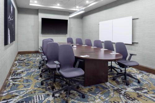 a conference room with a table and chairs and a whiteboard at Embassy Suites By Hilton Grand Rapids Downtown in Grand Rapids