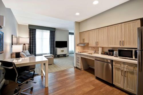 a large kitchen with a desk and a living room at Homewood Suites By Hilton Greenville Downtown in Greenville