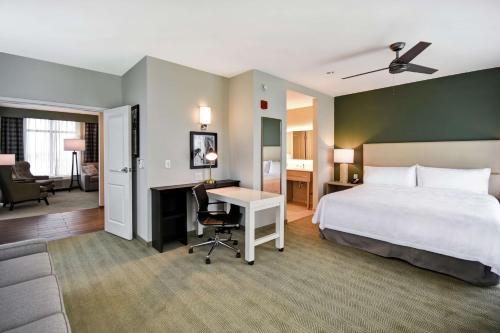 Homewood Suites By Hilton Greenville Downtown في غرينفيل: غرفة في الفندق مع سرير ومكتب