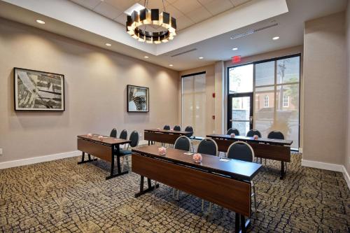 a conference room with desks and chairs and a chandelier at Homewood Suites By Hilton Greenville Downtown in Greenville