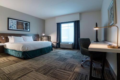 een hotelkamer met een bed en een bureau bij Hilton Garden Inn Spartanburg in Spartanburg