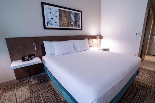 a large bed in a hotel room with a white bedspread at Hilton Garden Inn Spartanburg in Spartanburg