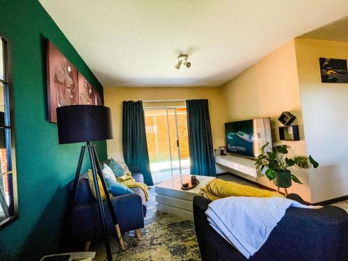 una sala de estar con una pared verde y amarilla en Melody, en Midrand