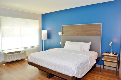 1 dormitorio con 1 cama grande y pared azul en Tru By Hilton Grand Junction Downtown, en Grand Junction