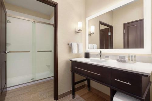 a bathroom with a sink and a shower with a mirror at Homewood Suites By Hilton Harlingen in Harlingen