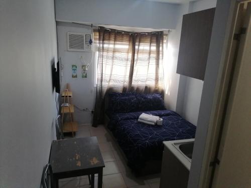 een kleine kamer met een blauw bed in een kamer bij Para Sa'yo in Manilla