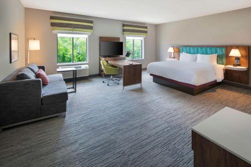 ビロクシにあるHampton Inn & Suites D'Iberville Biloxiのベッドとデスクが備わる広い客室です。