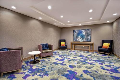 a large waiting room with chairs and a fireplace at Homewood Suites By Hilton Orange New Haven in Orange
