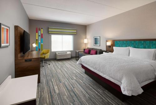 um quarto de hotel com uma cama e um sofá em Hampton Inn Franklin, IN em Franklin