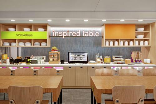 a restaurant with wooden tables and a upgraded table at Home2 Suites By Hilton Fernandina Beach on Amelia Island, FL in Fernandina Beach