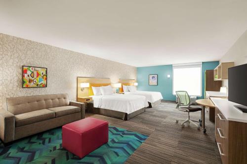 费南迪纳比奇Home2 Suites By Hilton Fernandina Beach on Amelia Island, FL的配有床和沙发的酒店房间