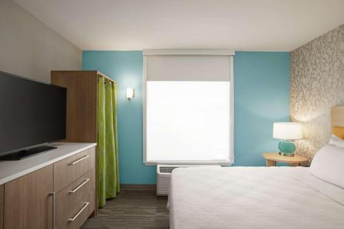 a bedroom with a bed and a large window at Home2 Suites By Hilton Fernandina Beach on Amelia Island, FL in Fernandina Beach