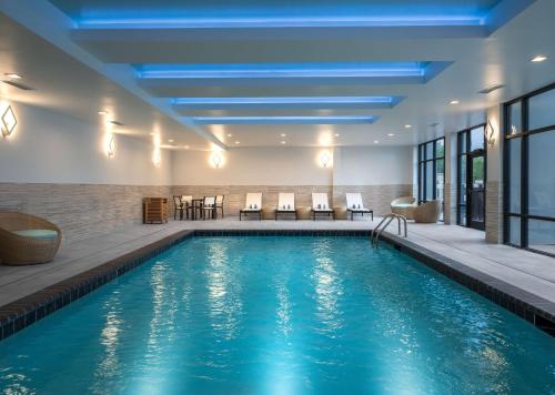a pool in a hotel with chairs and tables at Homewood Suites By Hilton Jackson Fondren Medical District in Jackson